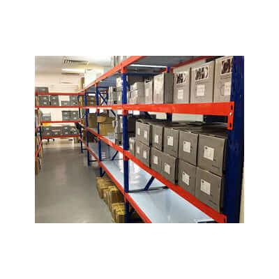 Industrial storage shelves in organized warehouse with labeled cardboard boxes and packages