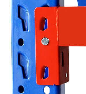 Close-up of red metal bracket bolted to blue perforated steel beam, industrial shelving support