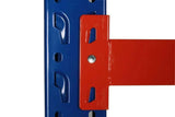Close-up of blue vertical steel shelving frame with red horizontal metal beam attachment in industrial warehouse